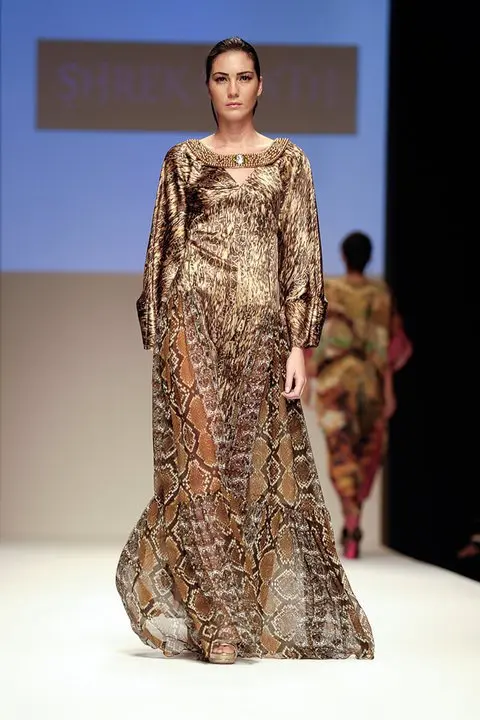 Arabian Nomads : Exclusive Arab Dress Collection at DFW, SS11 12 Long thobe-style dress with boat neck embroidered in Swarovski pearls, printed in stained and animal textures, with added chiffon panels at the hip and exaggerated barrel-cut cuffs.